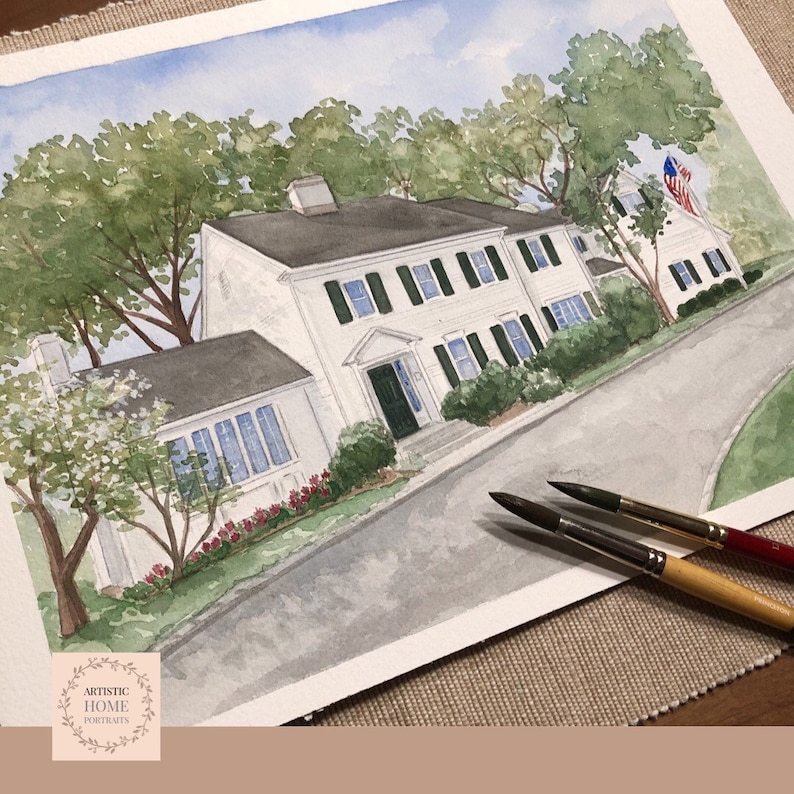 May include: Watercolor painting of a white house with green shutters and a black roof. The house is set on a slight incline with a driveway and surrounded by trees. The painting includes the text "ARTISTIC HOME PORTRAITS".