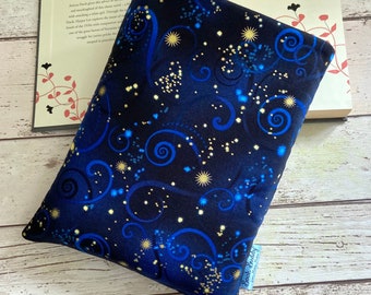 May include: A blue and gold fabric with a swirling pattern and stars. The fabric has a label that says "Brook Bradley Fabrics".