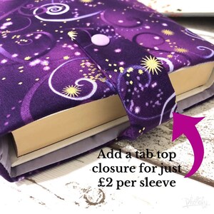 May include: A purple book sleeve with a celestial design featuring swirling patterns and starbursts. The sleeve has a tab closure with a light purple button. The text "Add a tab top closure for just" is visible.