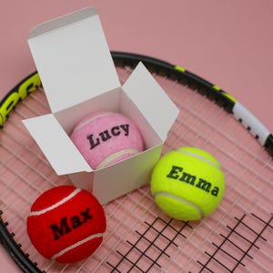 Une balle de tennis colorée personnalisée présentée dans une boîte
