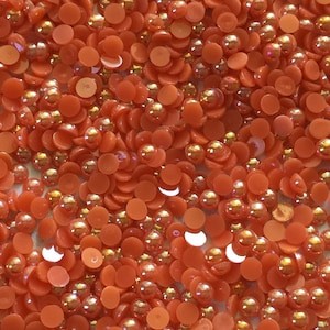 Könnte beinhalten: Ein Nahaufnahmebild einer großen Menge runder und flacher orangefarbener und goldener Kunststoffverzierungen. Die Verzierungen sind perfekt zum Basteln und Dekorieren.