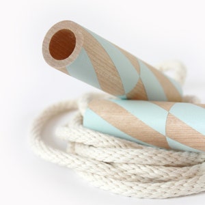 May include: A wooden jump rope with a white rope and blue and brown striped handles.