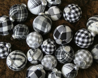 May include: A collection of black and white plaid Christmas ornaments. The ornaments are made of fabric and have a button detail.