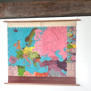 May include: A vintage map of Europe from 1914, displayed on a wooden rod. The map features a vibrant color palette with shades of blue, pink, green, and yellow, depicting the geographical regions. The map is labeled "EUROPE 1914".