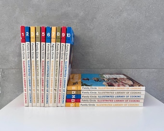 May include: A set of 15 vintage cookbooks with colorful spines. The books are titled "Family Circle Illustrated Library of Cooking" and are numbered 1 through 15.