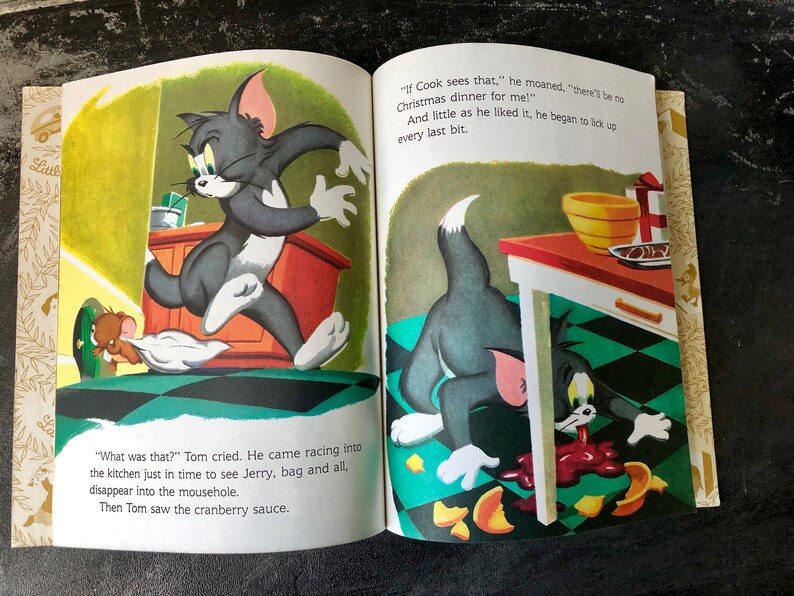 May include: Tom and Jerry cartoon illustration from a children's book. Tom is running away from Jerry, who is hiding in a mousehole. Tom is licking up cranberry sauce that has spilled on the floor. The text reads "What was that?" Tom cried. He came racing into the kitchen just in time to see Jerry, bag and all, disappear into the mousehole. Then Tom saw the cranberry sauce. "If Cook sees that," he moaned, "there'll be no Christmas dinner for me!" And little as he liked it, he began to lick up every last bit.