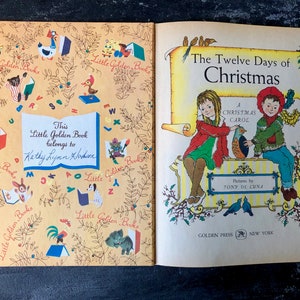 May include: An open book with a yellow cover and illustrations of animals and letters. The book is titled "The Twelve Days of Christmas" and features a Christmas carol. The book is a Little Golden Book and has a personalized inscription.
