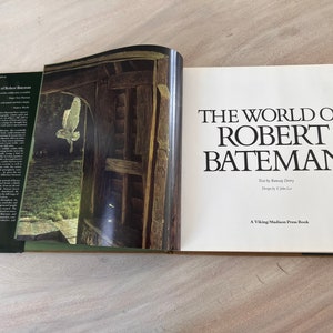 May include: A book titled "The World of Robert Bateman" with a white owl flying through a doorway on the cover.