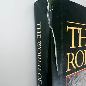 May include: A black hardcover book with gold lettering on the spine that reads "The World of Robin", and gold lettering on the front cover that reads "The World of Robin".