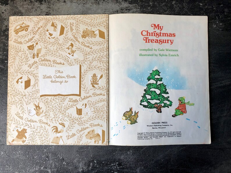 May include: A vintage Little Golden Book titled "My Christmas Treasury" compiled by Gale Wiersum and illustrated by Sylvia Emrich. The cover features a snowy scene with a green Christmas tree and a child in a red coat standing near it.