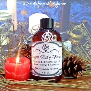 May include: A brown glass bottle with a black cap and a silver pentagram charm. The bottle is labeled "Pagan Holy Water Witches Blessing Water Home Blessings & Protection The Alchemists Cauldron 4 fl. oz."