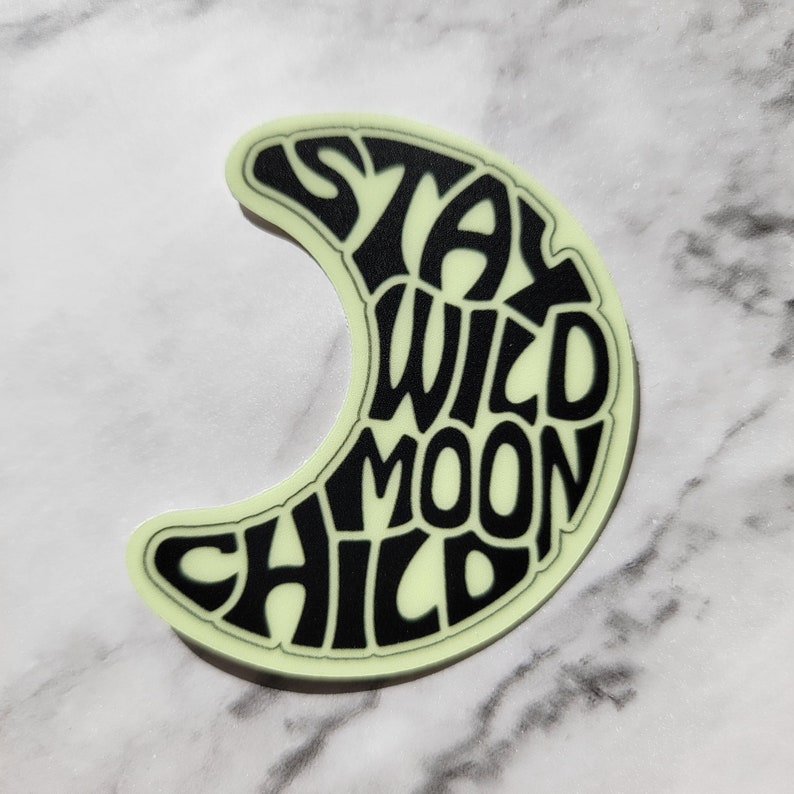 Pu&ograve; includere: Un adesivo che brilla al buio a forma di luna crescente con il testo "Stay Wild Moon Child" in nero.