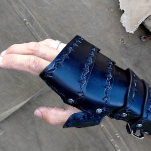 A Leather full gauntlet, dyed black, shown being worn from a POV angle.