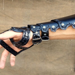 A leather demi gauntlet and bracer, shown being worn from the underside, revealing how the layers stack upon one another.