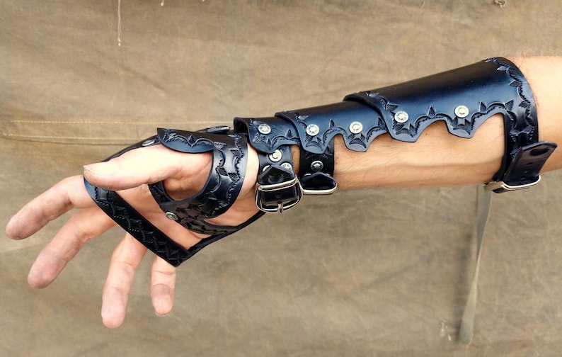 A leather demi gauntlet and bracer, shown being worn from the underside, revealing how the layers stack upon one another.