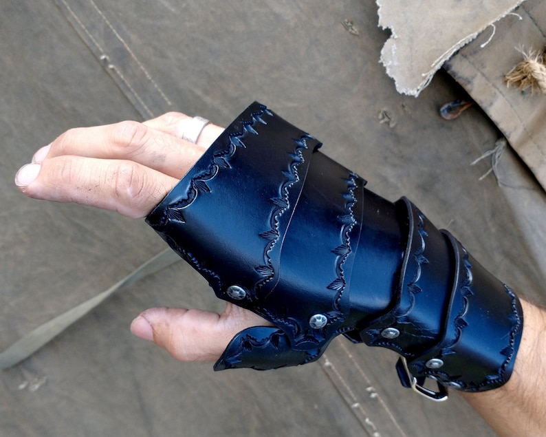 A Leather full gauntlet, dyed black, shown being worn from a POV angle.