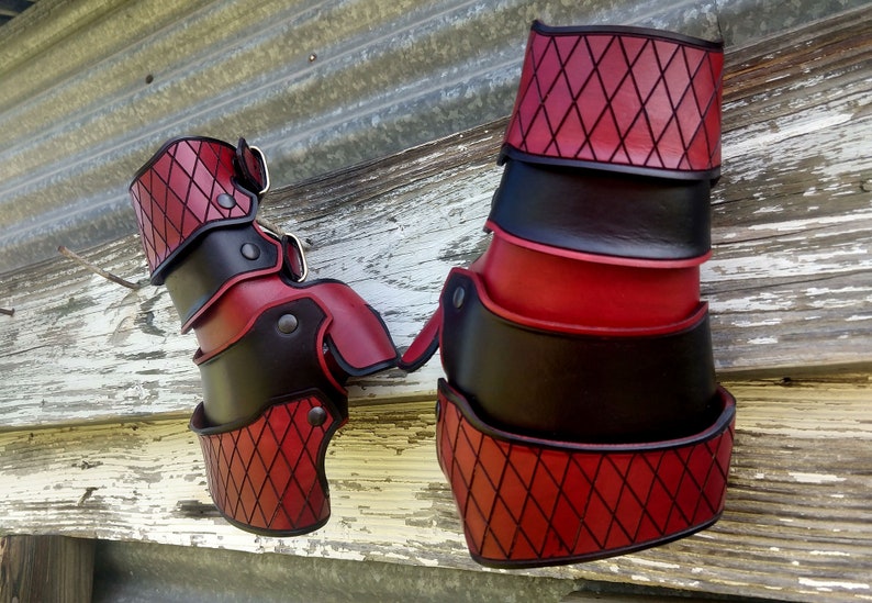 A set of leather gauntlets, dyed red & black in a diamond pattern, as requested for a Harley Quinn Cosplay.