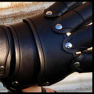 A side-by-side example of the different borders available for leather armor. 

The left panel shows blank plates, the center panel is a carved line, and the right has a tooled pattern.