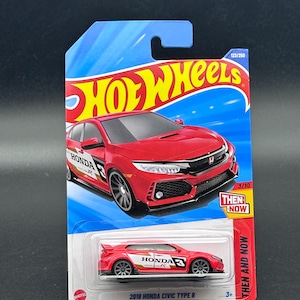 May include: A red 2018 Honda Civic Type R Hot Wheels die-cast car. The car has black wheels and white and red accents. The packaging includes the Hot Wheels logo, the text "THEN AND NOW", and the number 123/250.
