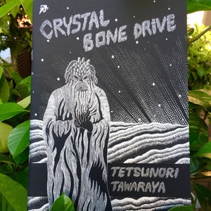 May include: Black and white illustration of a creature with a long beard and a pointed hat. The creature is standing in front of a starry sky and a wavy landscape. The text "CRYSTAL BONE DRIVE" and "TETSUNORI TAWARAYA" is printed in white on a black background.