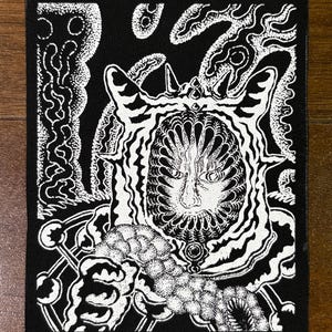 Könnte beinhalten: Schwarz-weiß Illustration auf schwarzem Stoff. Das Kunstwerk zeigt ein stilisiertes Gesicht mit komplizierten Mustern und wirbelnden Linien. Das Design hat eine surreale Qualität mit Punktmustern und hohem Kontrast.