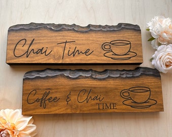 May include: Two wooden signs with a rustic, live edge finish. The top sign reads "Chai Time" with a stylized cup and saucer. The bottom sign reads "Coffee & Chai TIME" with a stylized cup and saucer.