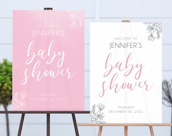 May include: Two welcome signs for a baby shower. The sign on the left is pink with white floral accents and the text "Welcome to Jennifer's Baby Shower" and "Thursday December 02, 2021". The sign on the right is white with black floral accents and the text "Welcome to Jennifer's Baby Shower" and "Thursday December 02, 2021".