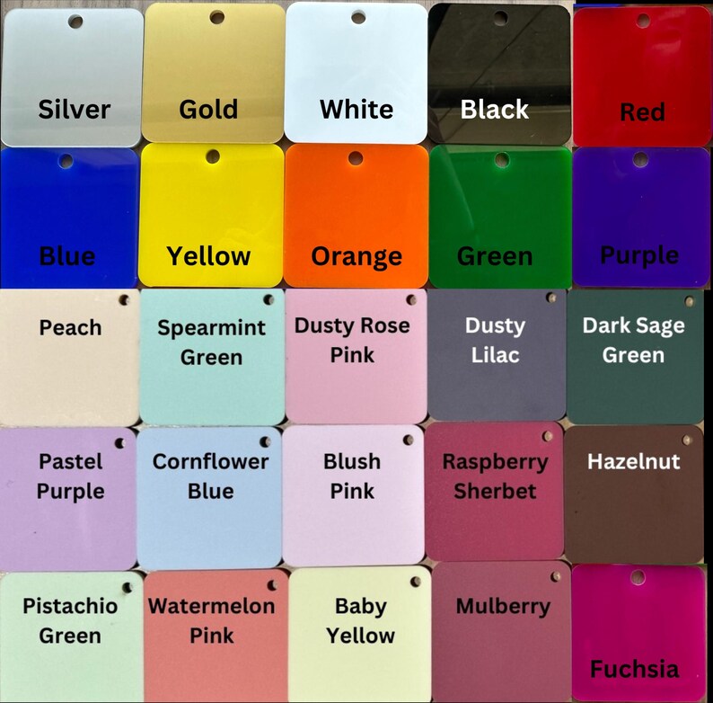 Op de afbeelding: Een verzameling vierkante acrylkleurstalen, elk gelabeld met een andere kleurnaam. Kleuren zijn onder meer zilver, goud, wit, zwart, rood, blauw, geel, oranje, groen, paars, perzik, spearmintgroen, stoffig roze, stoffig lila, donker saliegroen, pastelpaars, korenbloemblauw, blushroze, frambozensherbet, hazelnoot, pistachegroen, watermeloenroze, babygeel, moerbei en fuchsia.