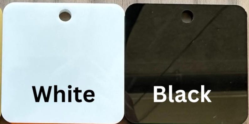 May include: Two square samples of paint, one white and one black. The samples are labeled "White" and "Black".