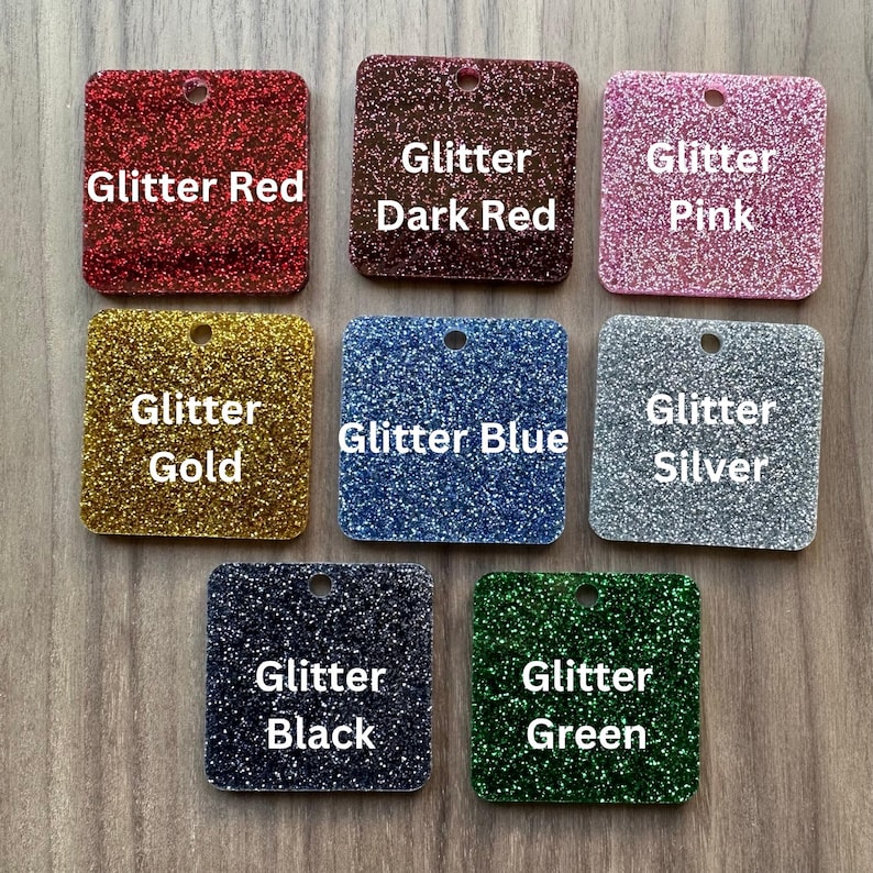 May include: Nine square pieces of glitter paper in various colors, including red, dark red, pink, gold, blue, silver, black, and green. Each piece has the word "Glitter" followed by the color name.