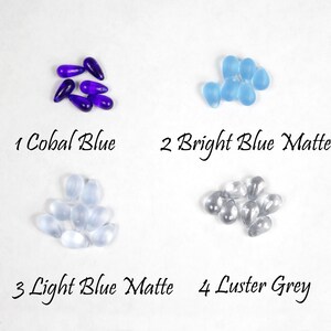 May include: Four piles of glass beads in different colors and finishes.  1 Cobal Blue, 2 Bright Blue Matte, 3 Light Blue Matte, 4 Luster Grey.