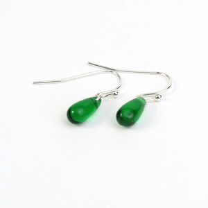 May include: A pair of silver dangle earrings with teardrop-shaped green glass beads.