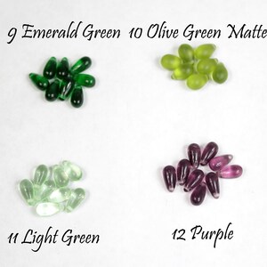 May include: Assortment of glass teardrop beads in various colors, including emerald green, olive green, light green, and purple. The beads are arranged in four groups, with each group labeled with a number and color name.