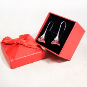 May include: A pair of pink crystal flower earrings in a red gift box with a red ribbon.