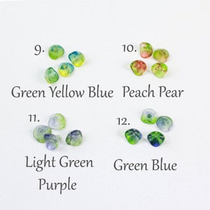 May include: Assortment of glass beads in various colors, including green, yellow, blue, peach, pear, light green, purple, and green blue. The beads are arranged in groups of four or five, with each group labeled with a number and a color description.