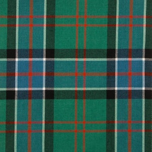 May include: A close-up of a green and blue plaid pattern. The design features a repeating grid of intersecting lines in green, blue, black, white, and red. The fabric has a textured appearance, suggesting a woven material.