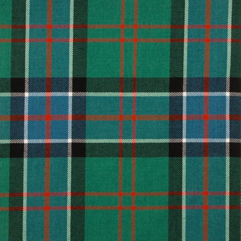 May include: A close-up of a green and blue plaid pattern. The design features a repeating grid of intersecting lines in green, blue, black, white, and red. The fabric has a textured appearance, suggesting a woven material.