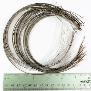 May include: A pile of silver-colored metal wire circles with small loops at the ends. The circles are approximately 2 inches in diameter. A ruler is visible at the bottom of the image, with markings from 0 to 6 inches.