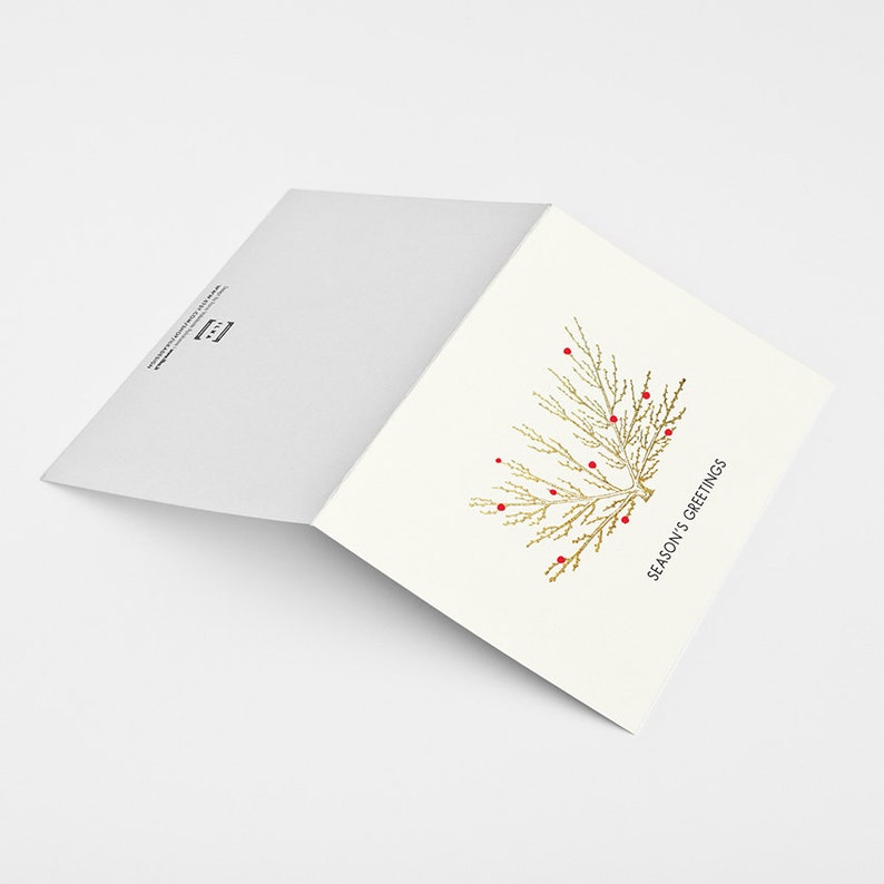 May include: A folded white card with a gold foil tree design and red berries. The text "Season's Greetings" is printed in black on the front of the card.