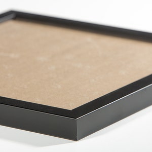 May include: Black picture frame with a brown mat.