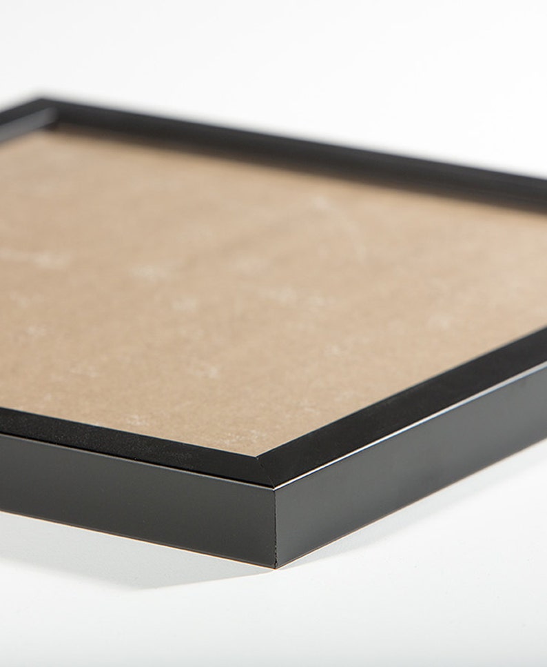 May include: Black picture frame with a brown mat.