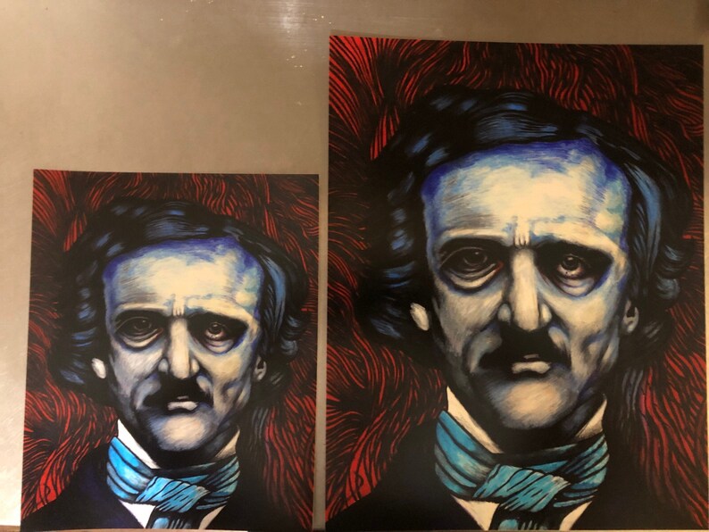 May include: Two framed prints of a portrait of Edgar Allan Poe. The portrait is a dark blue and white illustration of Poe with a dark blue background. The background of the larger print is a red and black abstract design. The background of the smaller print is a red and black abstract design.