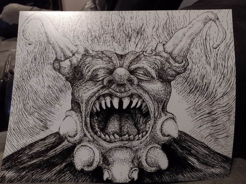 May include: A black and white pen and ink drawing of a grotesque, demonic creature with a large, open mouth and sharp teeth. The creature has horns and a large, bulbous nose.