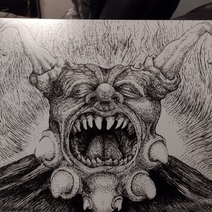May include: A black and white pen and ink drawing of a grotesque, demonic creature with a large, open mouth and sharp teeth. The creature has a large, bulbous nose and two long, pointed ears.