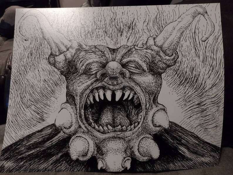 May include: Black and white ink drawing of a grotesque, demonic clown with a wide open mouth, sharp teeth, and horns. The clown is wearing a ruff collar with multiple round embellishments.