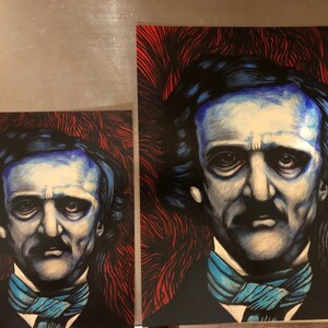 May include: Two different sized prints of a portrait of Edgar Allan Poe. The portrait is a close-up of his face and features a blue and black color scheme. The background is a red and black abstract design.