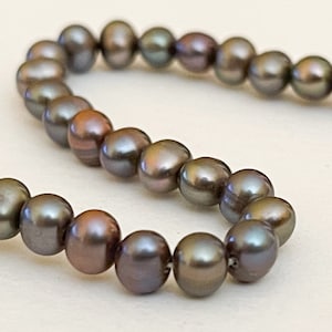 May include: A strand of dark grey pearls with a slight iridescent sheen.