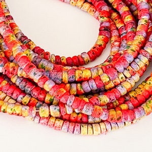 May include: A strand of colorful, speckled beads in shades of red, yellow, and purple. The beads are small and round, and they are strung together on a clear thread.