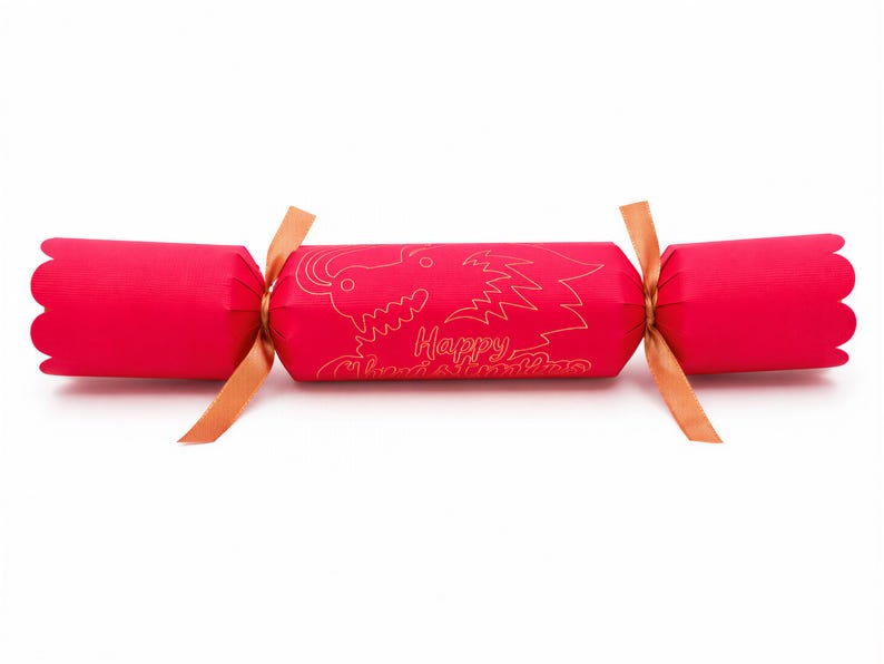 A red Christmas cracker with a gold dragon design and the text "Happy Christmas" printed on it.