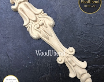 May include: A decorative wooden embellishment with intricate carvings and a light brown color. The embellishment is shaped like a long, thin leaf with a pointed tip. It is a new release from WoodUbend, a company that makes 3rd generation improved design wood products.